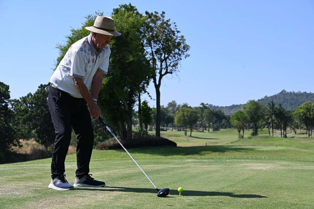 A golfer lining up a tee shot with a driver
